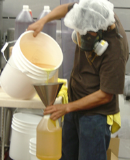Worker pouring flavoring chemicals