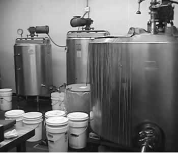 Image of three large mixing tanks and  eight five-gallon buckets